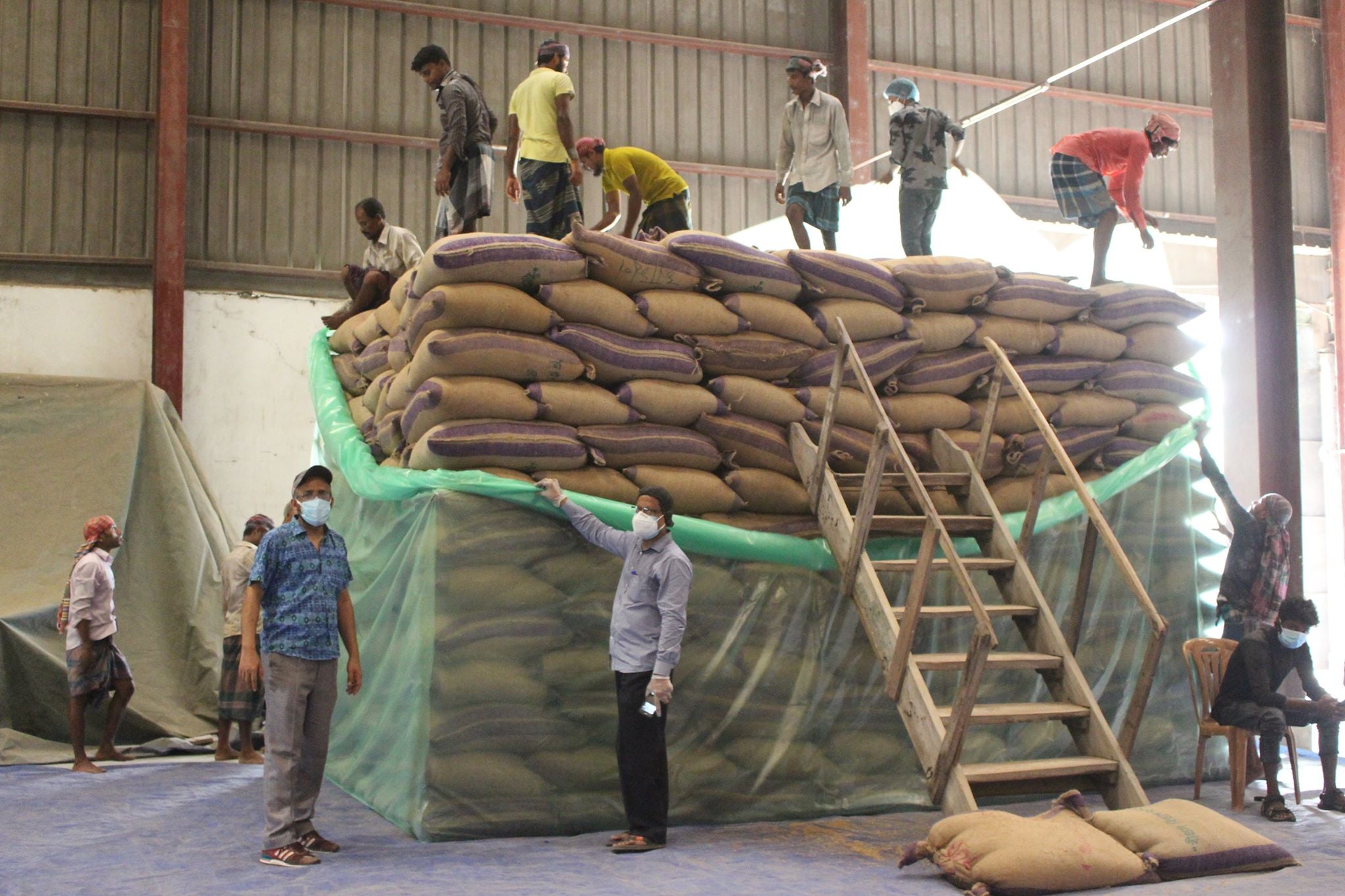 People piling bags of grain