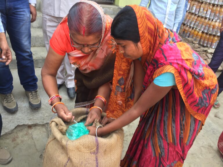 two Indian women with bag of grain